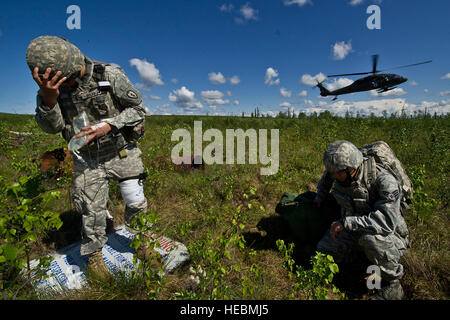 US Army 1st Lt. Matthew Rankin, 2nd Stryker Brigade Combat Team, 25. Infanterie-Division, Schofield Barracks, Hawaii und US Air Force Senior Airman Jin Lee, 15. medizinische Operations Squadron, schützen ihre Augen vor einem US-Army UH-60 Black Hawk medizinische Evakuierung Hubschrauber bei einem Unfall Evakuierung Szenario im gemeinsamen Pazifik Bereich Complex in der Nähe von Eielson Air Force Base in Alaska, als Teil des Red-Flag-Alaska 12-2. Rote Fahne-Alaska ist eine Pacific Air Forces gesponsert, Gelenk/Koalition, taktische Luft-Bekämpfung der Arbeitslosigkeit-Übung, die die Einsatzfähigkeit der beteiligten Einheiten entspricht. Stockfoto