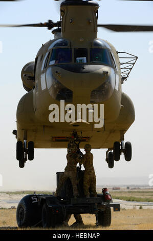 US-Soldaten, zugewiesene 1569th Transportation Company, schließen Sie eine Schlinge Last ein Chinook im Camp Marmal, Afghanistan, 30. Juni 2014. Bravo Company, 1. Bataillon, 169. General Support Aviation Battalion, eine CH-47F Chinook Schwerlast-Hubschrauber-Einheit bestehend aus Georgia und Alabama Gardisten, Luftunterstützung für die Ausbildung vorgesehen. Die Ausbildung kann verwendet werden, um Übergang Operationen aus Afghanistan zu unterstützen. (Foto: U.S. Air Force Senior Airman Sandra Welch) Stockfoto