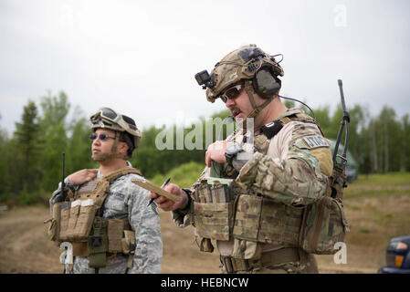 US Air Force Staff Sgt Eugene Tabita, eine 14. Fighter Squadron individuelle Medizintechniker aus Misawa Air Base, Japan, links, Uhren als Staff Sgt Jacob Rinker, ein 13. Air Special Operations Squadron gemeinsamen terminal Angriff Controller, Fort Carson, Colorado, in der Nähe Koordinaten Luftunterstützung für die US-Armeesoldaten im gemeinsamen Training Alaskakette Pazifik, Alaska, 8. Juni 2016, während rote Fahne-Alaska 16-2. Die Übung bietet einzigartige Möglichkeiten, verschiedene Kräfte in Gelenk, Koalition und multilaterale Ausbildung von simulierten vorwärts operativen Basen zu integrieren. (U.S. Air Force Photo von Personal S Stockfoto