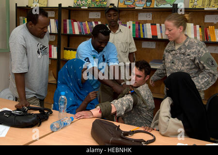 Grundschullehrer aus Dikhil, Dschibuti, gelten eine Blutsperre für US-Armee Spc. Adam Linden, kombiniert Joint Task Force-Horn von Afrika Dschibuti gemeinsame Civil Affairs Team Medic in einem erste-Hilfe-Workshop vom 28.-31. Oktober 2012 statt. US-Armee Soldaten aus dem 448th CA-Bataillon und zugewiesen, kombiniert Joint Task Force-Horn von Afrika eine Partnerschaft mit der Dikhil Office of Education, beste ärztliche und zahnärztliche Praxis mit 40 Djiboutian Instruktoren aus vier Grundschulen der Bezirk zu teilen. (US Air Force Foto von Staff Sgt. Christopher Ruano/freigegeben) Stockfoto