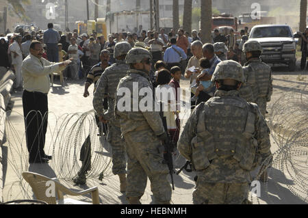 US-Armee Soldaten, Headquarters Company, 2. Bataillon, 69. Armor Regiment, Fort Benning, Georgia, befestigt das 2nd Brigade Combat Team, 2. US-Infanteriedivision, Hand, finanzielle und materielle Hilfe für die Bürger von East Bagdad in der Nähe von Forward Operating Base Loyalität, 28. August 2007. Stockfoto