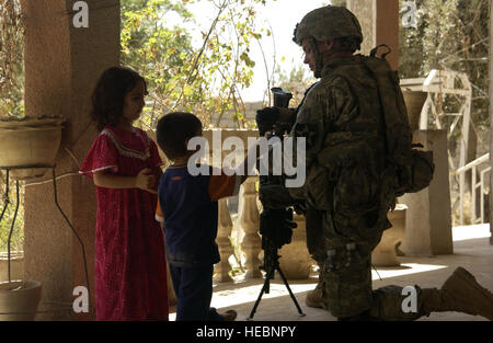 US-Armee Pfc. Scott Hall der Bravo Company, 1. Bataillon, 23. Infanterie-Regiment, 3-2 Brigade Combat Team, 2. US-Infanteriedivision spricht mit Kindern außerhalb einer gesicherten Haus befindet sich in Baqubah, Irak am 21. Juli 2007.  (Foto: U.S. Air Force Airman 1st Class Christopher Hubenthal) (FREIGEGEBEN) Stockfoto