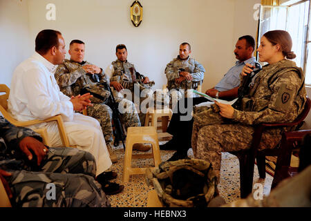 US Army 1st Lt. Julie Leggett (rechts), Executive Officer für die Sicherheitsabteilung, 25. spezielle Truppen Bataillon 25. Infanterie-Division, eine irakische Polizisten und andere Mitglieder der Sicherheitsabteilung sprechen mit ein lokaler Unternehmer während einer Projektstudie in Hamra, Irak, 26. August. Stockfoto