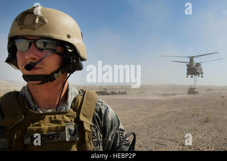 US Air Force Tech Sgt. Jason Bischoff, 820th RED HORSE Luft Flug in der Luft Fahrzeug Ausrüstung Betreiber Handwerker, wartet als ein Nevada Army National Guard 1. Bataillon, 189. Aviation Company CH-47 Chinook-Hubschrauber fällt eine Caterpillar D9 Planierraupe, 23. Juli 2011, Nellis Air Force Base, Nevada Nevada Army National Guard und der 820 RHS Luft Flug geschult zusammen, um ihre Interoperabilität während der Durchführung Luft Tropfen verbessert und Sling-Load Operationen. Stockfoto