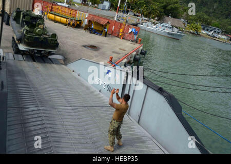 Ein US-Navy-Matrose führte ein mittleres taktisches Fahrzeug auf die vom Military Sealift Command gecharterte HSV 2 Swift während der Southern Partnership Station 2013 in Santo Tomas de Castilla, Guatemala, und unterstützte den regionalen zivilen und maritimen Kompetenzaufbau. Stockfoto