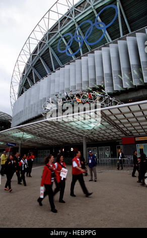 Am 15. September 2000, vor der Eröffnungszeremonie, passieren Besucher die Olympischen Ringe im Olympiastadion von Sydney. US-Militärsportler traten als Teil des US-Olympiateams an, wobei Athleten, Stellvertreter und Trainer alle vier Dienststellen bei mehreren Sportveranstaltungen repräsentierten. Stockfoto