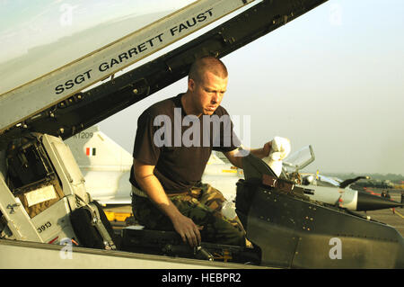 KALAIKUNDA AIR STATION, Indien (AFPN)--Crewchief Staff Sgt Garrett Faust reinigt das Heads-up Display auf seiner f-16 Fighting Falcon hier. Die Falcons fliegen unähnlich Luft Kampfeinsätze gegen die indischen MiGs--wie im Hintergrund-- und andere Flugzeuge während des Trainings Cope Indien 06, die 19. November endet. Der Sergeant ist von der 35. Aircraft Maintenance Squadron in Misawa Air Base, Japan. (Foto: U.S. Air Force Tech SGT Martin Jackson) Stockfoto