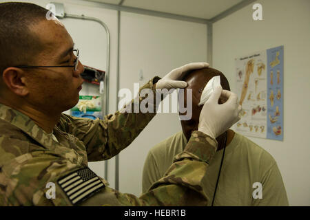 US Air Force Senior Airman Jin Lee, eine Luft-und Medizintechniker zugewiesen der 125. Transportation Company, ändert sich den Verband der US Armee Sgt. Vincent Zeupifatuung 66. Transportunternehmens während eines Follow-up Termins 7. März 2013, Camp Leatherneck, Afghanistan. Lee ist ein gemeinsamer Expeditionary beauftragt Flieger mit dem 466th Air Expeditionary Geschwader. JET-Piloten werden mit Einheiten der Armee an rund 80 Standorten in ganz Afghanistan zu kritischen Fähigkeiten und dynamische Führung eingebettet. (Foto: U.S. Air Force Staff Sgt Marleah Miller) Stockfoto