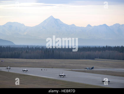 Republik der Korea Luftwaffe (ROKAF) F - 15K Slam Eagle multi-Role Kämpfer Flugzeug Taxi in Richtung ihrer Rampe Raum auf der Eielson Air Force Base in Alaska, Flightline 10. Oktober 2016, als ein US-Air Force f-16 Fighting Falcon zur 18. Aggressor Squadron versetzt gegenüber seinem Hangar taxis, nachdem die beiden gegensätzlichen Kräfte ihre erste rote Fahne-Alaska (RF-A) 17-1 Kampftraining Mission abgeschlossen. RF-A ist eine Reihe von Pacific Air Forces unter der Regie von Kommandant Bereich Übungen entscheidend für die Wahrung von Frieden und Stabilität in der Indo-Asien-Pazifik-Region, und die US-Einheiten und Partnerland Kräfte wie Stockfoto