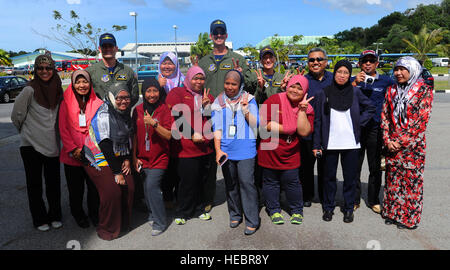 RIMBA AIR BASE, Brunei - Mitglieder der Pacific Air Forces demo Team Pose für ein Gruppenfoto mit lokalen Staatsangehörigen an Bord ein auf der Flightline auf Rimba Luftwaffenstützpunkt während der 4. Biennale von Brunei Darussalam Verteidigung Weltausstellung, 3. Dezember 2013. Gemeinsame Basis Pearl Harbor-Hickam Personal werden die c-17 Globemaster III durch statische Displays und Luftaufnahmen Demonstrationen während BRIDEX präsentieren.  BRIDEX 13 ist eine Gelegenheit für networking und sharing-Technologie mit regionalen Partnern und Verbündeten die baut starker multilaterale Beziehungen, Zusammenarbeit erhöht und erhöht die Bereitschaft für Stockfoto