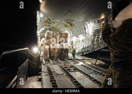 US-Flieger zugewiesen, 386th Expeditionary Logistik Bereitschaft Squadron und Flieger bereitgestellt von Joint Base McGuire-Dix-Lakehurst, New Jersey, laden Paletten Flügelschlagfrequenz Beihilfen für Syriens Oppositionskoalition auf ein Flugzeug der Luftwaffe c-17 Globemaster III an einer geheimen Basis in Südwestasien 21. Mai 2013 gebunden. US-Truppen leistete humanitäre Hilfe für Flüchtlinge von den syrischen Bürgerkrieg. (US Air Force Foto von Senior Master Sergeant George Thompson/freigegeben) Stockfoto