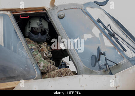 Eine afghanische Luftwaffe pilot fährt herunter einen Mi-17 Hubschrauber wie ein Zug beraten unterstützen Befehl-Air Mi-17 Air Berater aus dem Cockpitfenster nach einer Trainingsmission am Kandahar Flugplatz, Afghanistan, 3. März 2016 aussieht. Mitglieder der 441sten Air Expeditionary Advisory Squadron an KAF arbeitete mit AAF Piloten bei Start, Landung und Notfall-Verfahren. (US Air Force Photo/techn. Sgt. Robert Cloys) Stockfoto