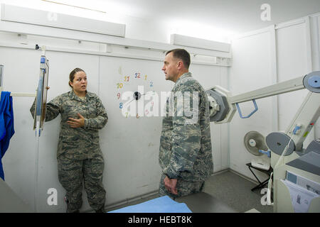 Staff Sgt Jennifer Thompson, 376th Expeditionary Praxisgemeinschaft diagnostische Bildgebung Techniker, erklärt Oberst John Millard, 376th Air Expeditionary Wing Commander bei Transit Center am Manas, Kirgisistan, 8. Januar 2014 den Röntgen-Prozess. Diagnostische Bildgebung Technologen sind Ausbildung in Anatomie, Patientenlagerung, Untersuchungstechniken, Ausrüstung-Protokolle, Strahlenschutz, Strahlenschutz und grundlegende Versorgung der Patienten. Thompson wird bereitgestellt von Wright-Patterson Air Force Base, Ohio, und ist ein Eingeborener von Liberty, Indiana (U.S. Air Force Photo/Senior Airman George Goslin) Stockfoto