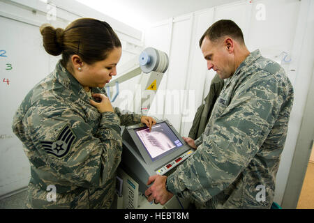 Staff Sgt Jennifer Thompson, 376th Expeditionary Praxisgemeinschaft diagnostische Bildgebung Techniker, beschreibt, wie Röntgenstrahlen, Oberst John Millard, 376th Air Expeditionary Wing Commander bei Transit Center am Manas, Kirgisistan, 8. Januar 2014 zu lesen. Diagnostische Bildgebung Technologen sind Ausbildung in Anatomie, Patientenlagerung, Untersuchungstechniken, Ausrüstung-Protokolle, Strahlenschutz, Strahlenschutz und grundlegende Versorgung der Patienten. Thompson wird bereitgestellt von Wright-Patterson Air Force Base, Ohio, und ist ein Eingeborener von Liberty, Indiana (U.S. Air Force Photo/Senior Airman George Goslin) Stockfoto