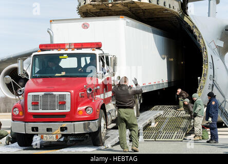 Techn. Sgt. Frederick Raffaelli, 9. Airlift Squadron Loadmaster marshallt Jimmie Richards und Fairfax County Fire Rescue Department, Virginia: Virginia Task Force 1 Fahrer/Mechaniker, wie er einen Western Star Constellation LKW angebracht zu einem 54-Fuß Dogge Anhänger rückwärts in den Frachtraum von einer C - 5 M Super Galaxy 3. März 2016, auf der Dover Air Force Base fährt, Del. Richards unterstützt die 92.000 Pfund LKW und Anhänger in den Frachtraum mit einem neuen Laden Rampensystem bekannt als DAMAS 26K steht für DOMOPS Luftbrücke modularen Ansatz Verbau. 900-Pfund-DAMAS 26K kann durch einrichten Stockfoto