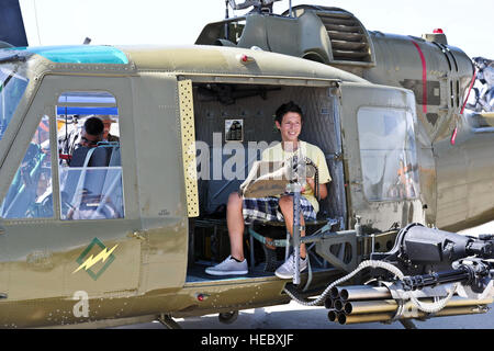 Ein Zuschauer sitzt in einem UH-1 b Huey Hubschrauber statische Anzeige während "Donner über Empire Air Fest" im März Air Reserve Base, Ca. 19. Mai 2012.  Luft Fest 2012 Funktionen militärischer und ziviler Boden und Luft Demonstration während einer zweitägigen Show.  (US Air Force Foto von techn. Sgt Joselito Aribuabo/freigegeben) Stockfoto