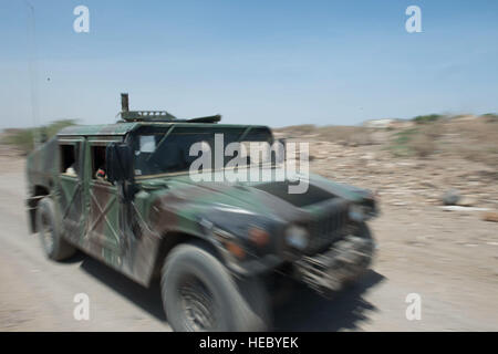 Ein Humvee Djiboutian Armed Forces (FAD) beschleunigt vorbei die Straße während eine berittene Patrouille im Rahmen der Höhepunkt Übungen mit der US Army und Navy außerhalb der Stadt Djibouti, Djibouti, 13. Mai 2015. US-Armeesoldaten aus dem 47. Transport Unternehmen, 142. bekämpfen Sustainment Support Battalion, 1. Panzerdivision Sustainment Brigade; die 123. Brigade Unterstützungsbataillon, 3. Brigade, 1. Panzerdivision; und US Navy Explosive Ordnance Disposal Teammitglieder mit Task Force Sparta durchgeführt gegen improvisierte Sprengkörper, medizinische und schwere Ausrüstung training. Die Übungen sind Stockfoto