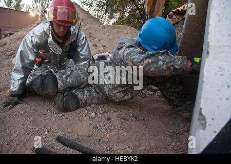 Links, zusammenbrechen techn. Sgt. Jeff Tomczak und Senior Airman Joshua Lupidi Blick ins Innere einer simulierten Konstruktion Website während einer Übung am Transit Center Manas, Kirgisistan, 28. September 2012. Die 376th Expeditionary Bauingenieur-Geschwader-Feuerwehr rettete zwei simulierte Opfer während der Übung. Tomczak und Lupidi sind 376 ECES Feuerwehrleute. Tomczak von 177 Kämpfer-Flügel, New Jersey Air National Guard bereitgestellt wird und Lupidi wird bereitgestellt von Fairchild Air Force Base, Wash Stockfoto