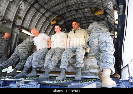 Oberst John Vaughn, 376th Air Expeditionary Wing stellvertretender Kommandant, Chief Master Sgt. Gregory Warren, 376th AEW Befehl Chef, Senior Airman Kody Novak, Air Transport Geselle, Staff Sgt Johnny Bernal, Luft-Transport-Handwerker, und große Troy Saechao, 376th AEW-Chef der Pläne und Programme, lehnen Sie sich in einer Palette der Verladung in einer c-17 Globemaster III am Transit Center Manas, Mai 20 , 2014.  Diese Paletten sind die letzten die Anlage Fracht aus dem Transit Center vor seiner Schließung dieses Sommers geflogen werden. (US Air Force Photo/Oberstleutnant Max Despain) Stockfoto