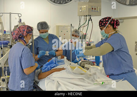 US Air Force 1st Lt. Christina Chuchuru, Air Force Captain Teresa Sellers, Armee Sgt. Mary Shannon McCay und Luftwaffe Oberstleutnant Allison Cogar bereiten sich ein Patient für eine Operation im OP-Saal im Craig Joint Theater Hospital in Bagram Airfield in Parwan Provinz, Afghanistan, 18. März 2014. (US Air Force Foto von Senior Master Sergeant Gary J. Rihn/freigegeben) Stockfoto