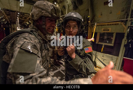 US Air Force Airman 1st Class Emily Mitchell, ein Loadmaster mit die 37th Airlift Squadron, erhält den Aktionsplan von Armee Sgt. 1. Klasse Luis Altamirano, ein Heli mit dem 4. Bataillon, 319th Airborne Field Artillery Regiment während eines Fluges zu Army Fallschirmjäger mit dem 1. Bataillon, 503. Infanterieregiment, 173rd Airborne Brigade Combat Team aus einem Flugzeug der Luftwaffe C-130J Super Hercules über Litauen Sept. 5 airdrop , 2014, während der Übung Steadfast Javelin II. Standhaft Javelin II ist eine NATO-geführten Übung, USA, NATO und internationalen Partner Kräfte für Sie vorbereitet Stockfoto