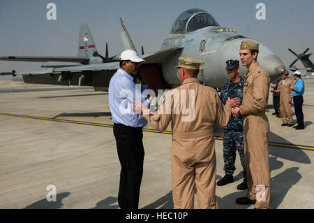 US Air Force Colonel Robert Nelson, Center, der Direktor von der US Air Forces Central Command Theater Zusammenarbeit Sicherheitssparte; Navy Lt. Tom Kilcline, rechts, eine F/A-18E/F Super Hornet Aircraft Pilot; und Marine Aviation Elektriker 1. Klasse Adam Jones, zweiter von rechts, mit einem Gast während 2014 Bahrain International Airshow in Sakhir Luftwaffenstützpunkt, Bahrain, 17. Januar 2014 sprechen. (US Air Force Foto von Staff Sgt. Stephany Richards/freigegeben) Stockfoto