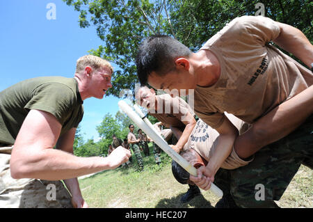 CHONBURI, Thailand – CPL. Colin Horne, ein Eingeborener von Houston, Texas und derzeit zugewiesen der Special Operations Training Group im Camp Hansen, Okinawa, Japan Versuche, thailändische Soldaten zu korrigieren, während sie ein Segment der nicht-tödlichen Ausbildung in Chonburi, Thailand am 1. Juni für nichttödliche Waffen-Lehrgang 2011(NOLES) zeigen. US-Marines von Camp Hansen, Okinawa, Japan trainieren Thai Militär und der Polizei verschiedene nicht-tödliche Techniken während Tüllen 2011. Das Seminar soll Bewusstsein für nicht-tödliche Waffen Taktik und Verfahren zur Aufrechterhaltung der Ordnung im niedrig-in Stockfoto