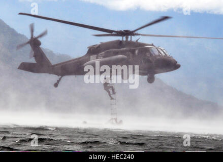 US-Militärangehörige mit Joint Task Force-Bravo Klettern eine Höhlenforschung Leiter befestigt an einem US-Army UH-60 Black Hawk Hubschrauber während einer Übung auf See Yojoa, Honduras, 25. Februar 2014. Mitglieder der Task Force und US-Soldaten mit der 7th Special Forces Group (Airborne) durchgeführt Helocast, Höhlenforschung Leiter und Overwater Hebezeug training während der Übung zu erhalten Kenntnisse und bereiten Sie für künftige Einsätze und Übungen in Mittelamerika. Gemeinsame Task Force-Bravo führt gemeinsame, kombinierten und ressortübergreifende Operationen und Einsätze im gesamten zugewiesenen geographischen Bereich unterstützt Stockfoto