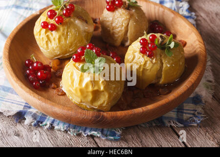 Bratäpfel mit Honig, Nahaufnahme Minze und roten Johannisbeeren auf einer Holzplatte. horizontale Stockfoto