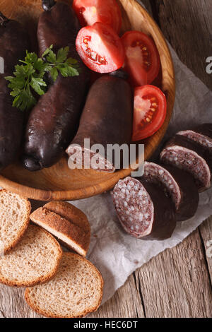 Frische Blutwurst mit Tomaten auf einen Teller Nahaufnahme. vertikale Ansicht von oben Stockfoto