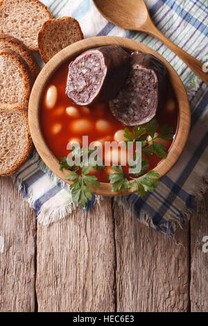 Köstliche Suppe mit Blutwurst Fabada Asturiana in einer Holzschale. vertikale Ansicht von oben Stockfoto