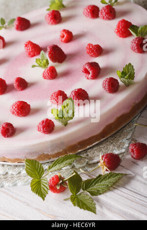 Gesundes Essen: Himbeer-Käsekuchen mit Minze und frischen Beeren Nahaufnahme auf dem Tisch. Vertikal Stockfoto