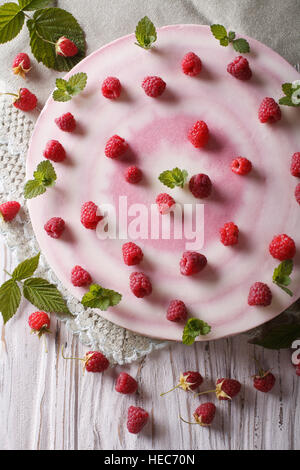 Käsekuchen mit frischen Himbeeren dekoriert mit Minze hautnah. vertikale Ansicht von oben Stockfoto