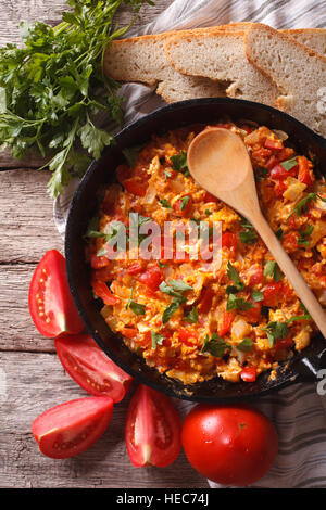 Menemen in einer Pfanne erhitzen und Zutaten auf den Tisch-Nahaufnahme. vertikale Ansicht von oben Stockfoto