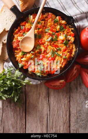 Menemen in einer Pfanne erhitzen und die Zutaten auf den Tisch. vertikale Ansicht von oben Stockfoto