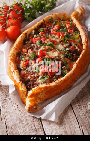 Türkische Pide-Pizza mit Rindfleisch und Gemüse Nahaufnahme auf dem Tisch. vertikale Stockfoto