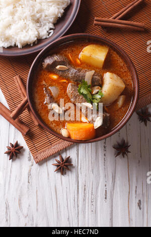 Heißen traditionelle Thai Rindfleisch Massaman Curry mit Erdnüssen und Reis-Beilage. vertikale Ansicht von oben Stockfoto