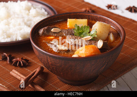 Traditionelle Thai Rindfleisch Massaman Curry mit Erdnüssen Nahaufnahme in eine Schüssel geben. Horizontale Stockfoto
