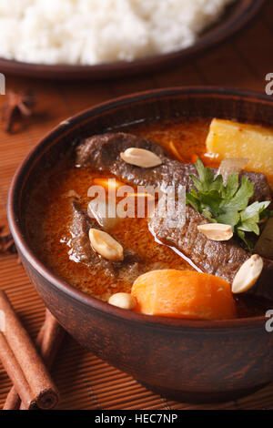 Thailändischen Massaman curry mit Rindfleisch und Erdnüsse auf den Tisch-Makro. vertikale Stockfoto