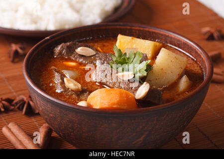 Thailändischen Massaman curry mit Rindfleisch und Erdnüsse auf den Tisch-Makro. Horizontale Stockfoto