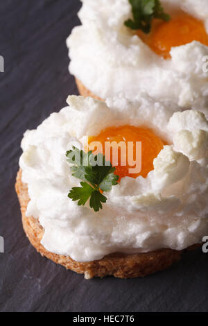 Eiern Orsini: gebackene geschlagene Eiweiß und Eigelb auf Toast. Vertikale Nahaufnahme Stockfoto