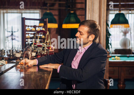Lächelnde attraktive junge Barkeeper Gläser abwischen und Gespräch mit Mann in der Bar Stockfoto