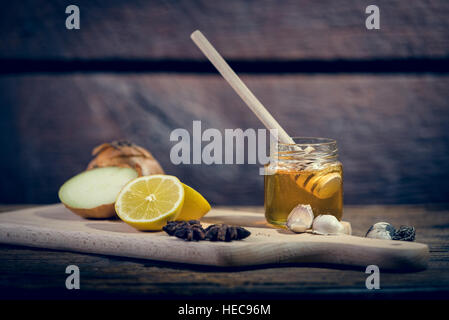 Natürliche Medicones gegen Grippe und Erkältung. Honig, Zitrone, heißen Tee, Zwiebeln und Knoblauch. Gesundheitskonzept. Stockfoto