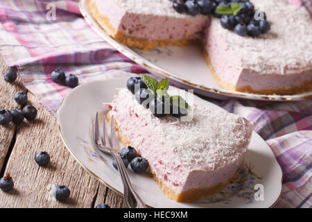 Hausgemachte Heidelbeer-Käsekuchen mit frischen Beeren und Kokosnuss Nahaufnahme auf einer Platte. horizontale Stockfoto