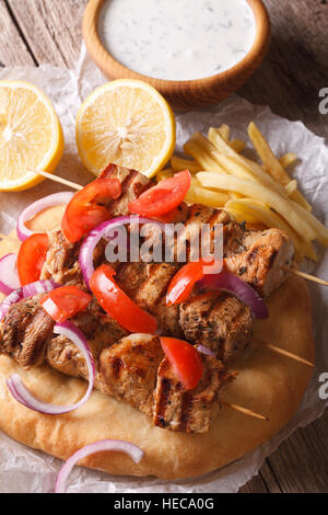 Griechische Souvlaki Kebab mit Tomaten und Zwiebeln Nahaufnahme auf dem Tisch. Vertikal, rustikal Stockfoto
