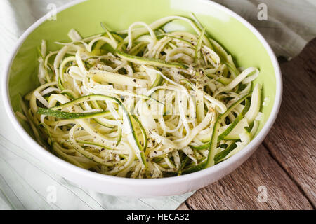 Natürliche Lebensmittel: rohe Zucchini Nudeln in einer Schüssel auf dem Tisch hautnah. horizontale Stockfoto