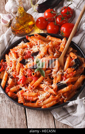 Italienische Küche: Penne mit Auberginen und Tomaten Nahaufnahme auf den Tisch und Zutaten. Vertikal Stockfoto