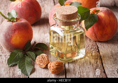 Natürliche Frische Pfirsich Öl in einer Glasflasche mit einer Tabelle Großaufnahme. Horizontale Stockfoto