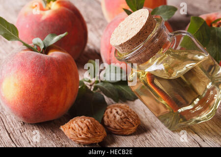 duftendes Öl Pfirsich Gruben in der Glas-Flasche-Nahaufnahme auf dem Tisch. horizontale Stockfoto