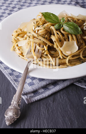 Linguine Pasta mit Pesto, Pinienkernen und Parmesan-close-up auf einem weißen Teller. vertikale Stockfoto